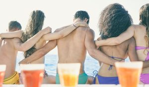 Back view of young friends sitting on boat in summer vacation - Group of people enjoying holidays together traveling around the sea - Friendship, bonding, fun, youth, travel concept - Retro filter